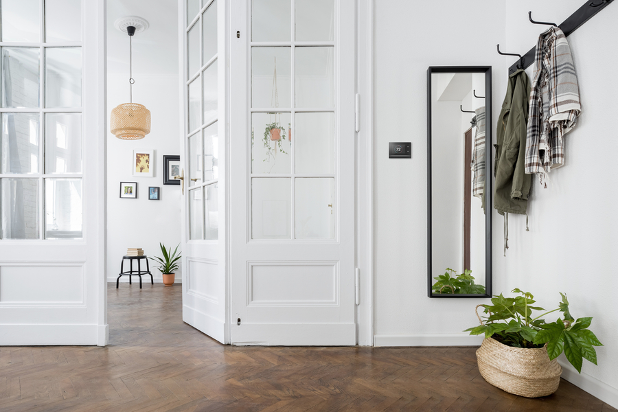 residential entryway with coats hanging on hooks and a partially opened door in the background