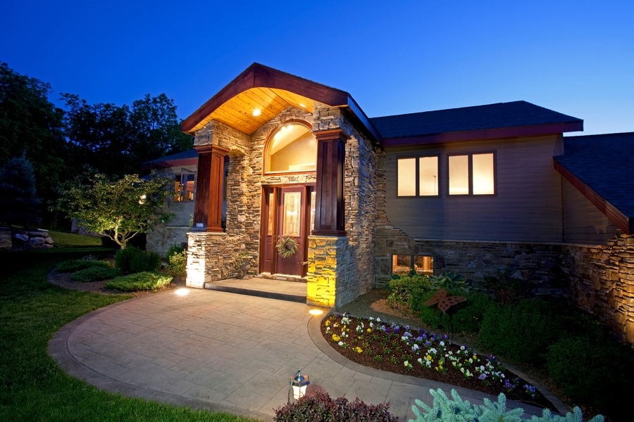 nighttime view of a home with landscape lighting illuminating architectural details 