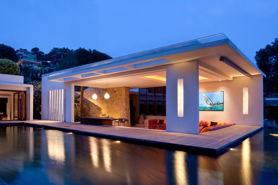  outdoor pool and patio area with lighting illuminating architectural details and the water