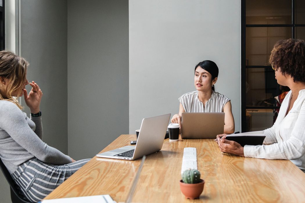 group of women sitting around a table discussing work