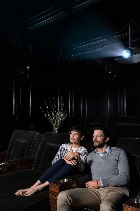 Couple watching TV in a dark home theater